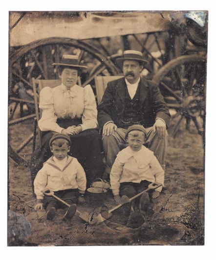 Tintype, depicting a family group of parents and two boys on the beach by the wheels of a bathing hut, 'Our family', by an unknown photographer, 1880s - 1890s