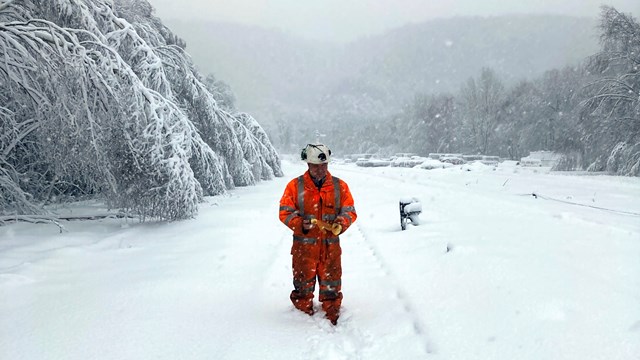 Disruption for Buxton and Hope Valley line passengers due to snow: Railway worker in snow up to 8 inches above the railhead at Grindleford copy