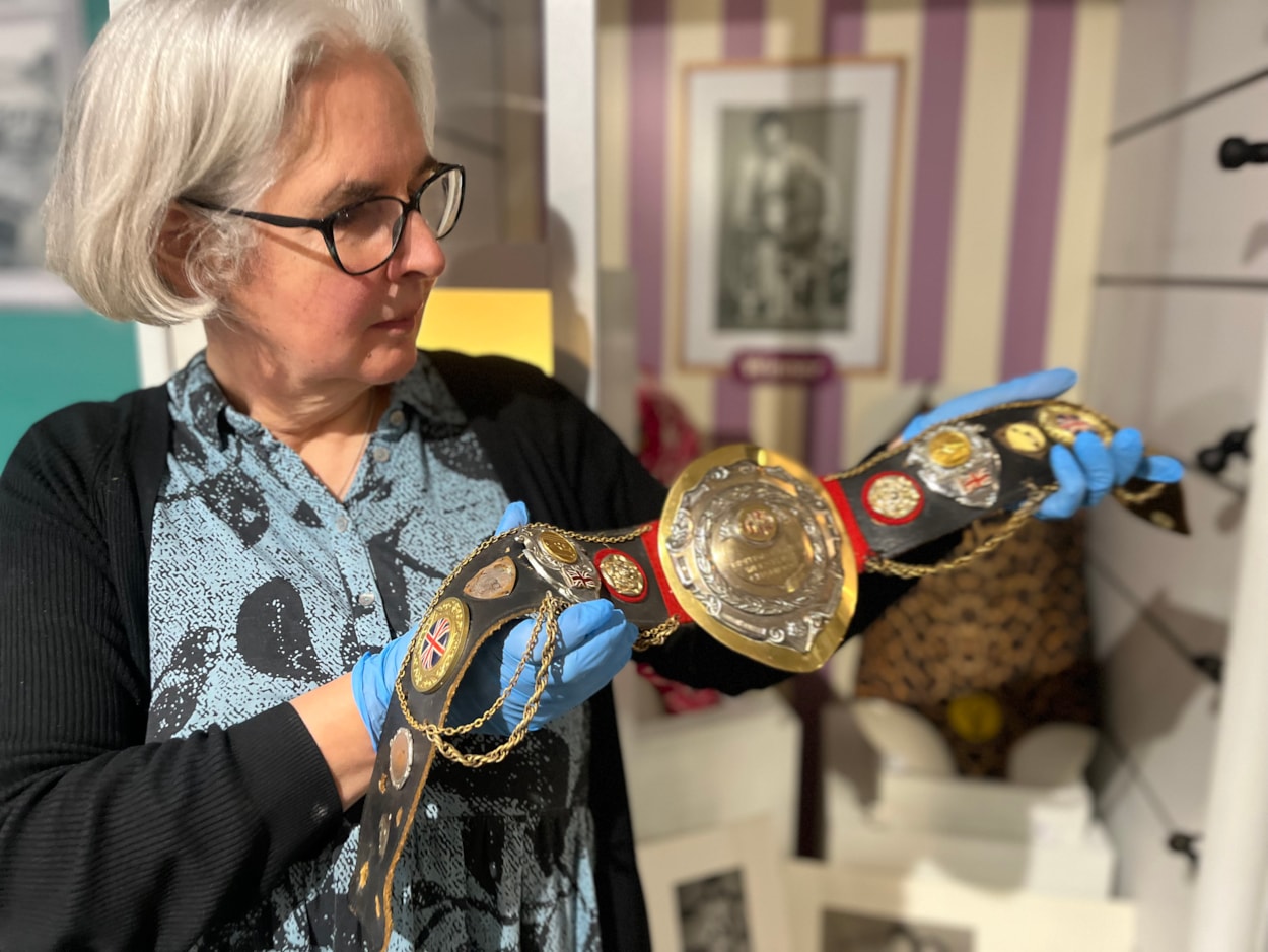 In the Picture: Curator Kitty Ross with a leotard and belt once worn by the city’s own female wrestler Sue Brittain, later known to opponents as Lady Satan.
Outside the ropes the pioneering grappler’s real name was Marjorie Farrar. She lived in Pudsey and throughout her career, fought a series of legal battles to be allowed to compete, including using equal opportunities legislation against the then Greater London Council during a two-day court hearing in 1979.