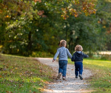 Two boys running down countryside lane