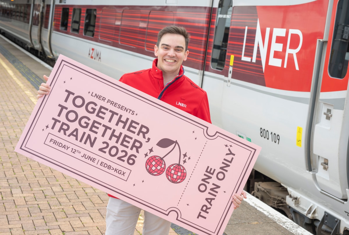 LNER Community Partnerships Manager next to LNER Azuma Train with giant ticket ahead of special Harry Styles-themed train