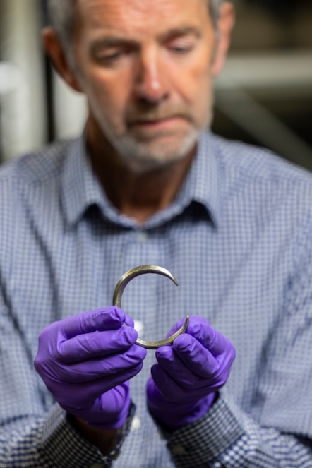 Assistant Curator Craig Angus with silver arm rings from the Burray Hoard. Photo © Duncan McGlynn (1)