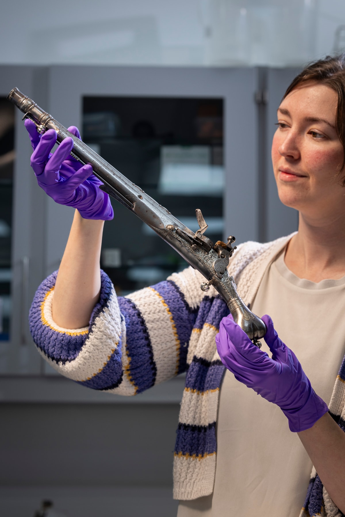Curator Ella Paul examines the pistol at National Museums Scotland. Image © Duncan McGlynn (3)