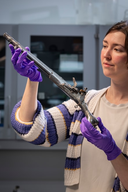 Curator Ella Paul examines the pistol at National Museums Scotland. Image © Duncan McGlynn (3)