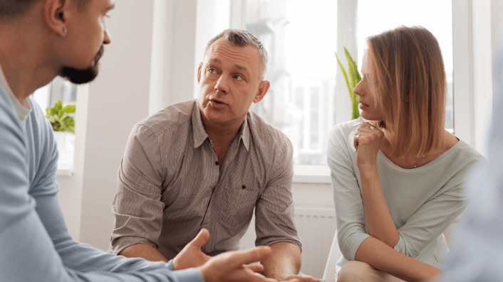 Three social workers are sitting together, having a discussion.