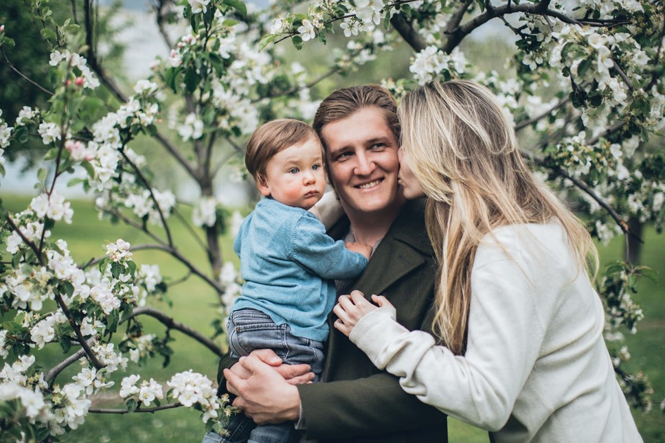 Couple with young child near blossom tree