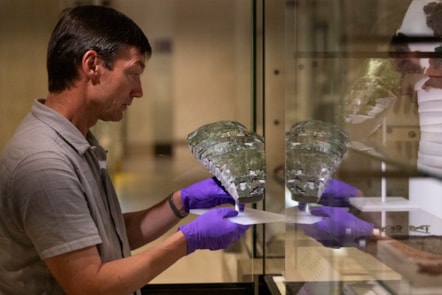 Dr Fraser Hunter installs the Roman arm guard in the Early People gallery at the National Museum of Scoltand. Image copyright Duncan McGlynn (5)