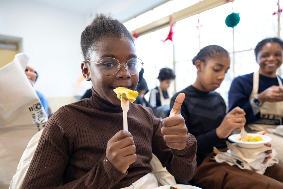 A young girl enjoying freshly-made ravioli at a Holiday Activities with Food event