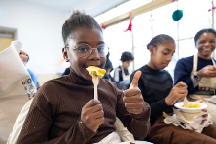 A young girl enjoying freshly-made ravioli at a Holiday Activities with Food event