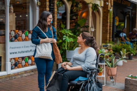 women chatting outside shop