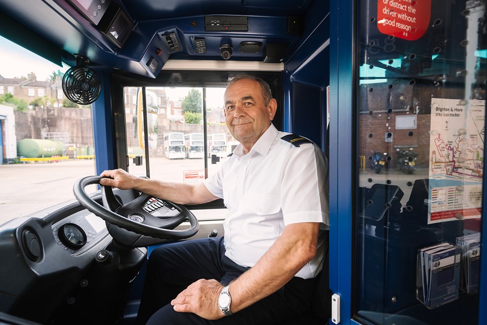 A bus driver behind the wheel of a bus in Brighton