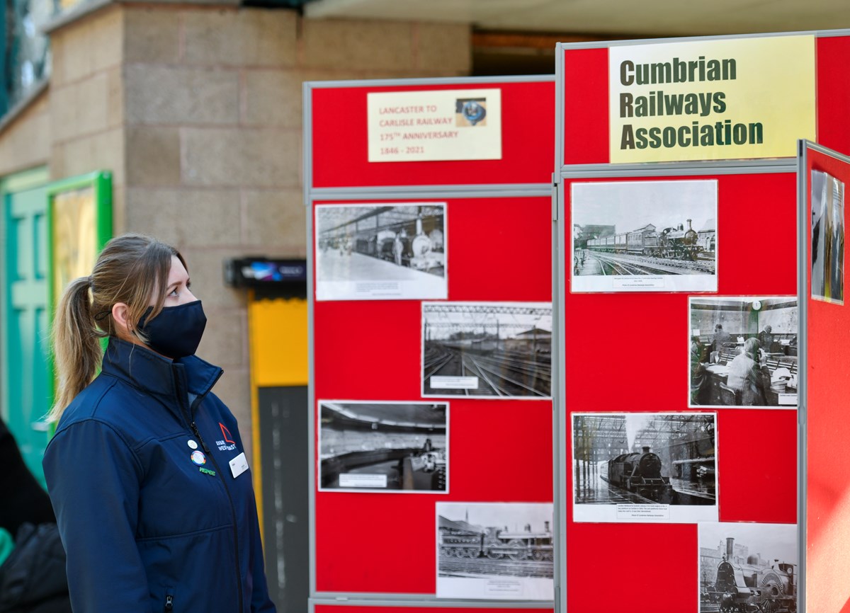Avanti West Coast Lancaster & Carlisle Railway 175 Anniversary 2: Katie Smith (Avanti West Coast Customer Service Assistant) viewing photographic display at Carlisle station