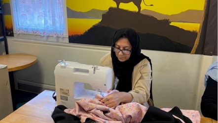 Afghan refugee Aziza at her sewing machine