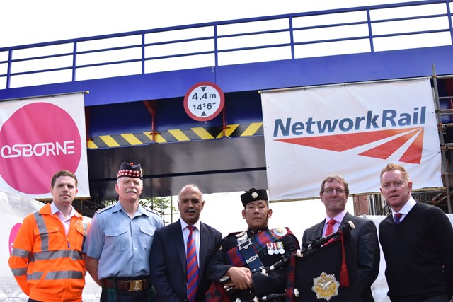 Aldershot Bridge 1: (l-r) Mark Evans, Asset Engineer at Network Rail; Lt. Col. MacGregor, Commander of Aldershot Army Garrison; Shahid Azeem, Chairman of Aldershot F.C.; a Gurkha Piper based at the Aldershot Garrison; Cllr David Clifford, Leader of Rushmoor Borough Council; Gary Waddock, Manager of Aldershot F.C.