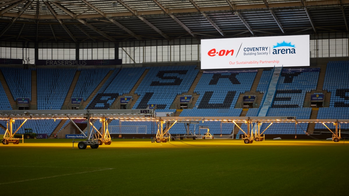 A picture of the football pitch at Coventry Building Society Arena with the E.ON sustainability banner.