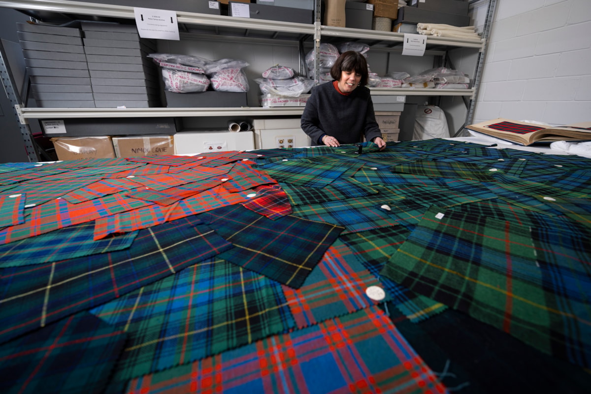 Curator Mhairi Maxwell examines the Paton tartan sample.Photo © Duncan McGlynn