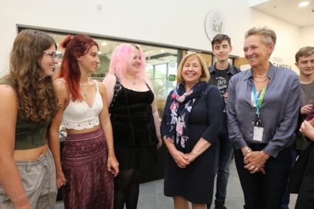 Lynne Neagle cabinet secretary for education and Coleg Cambria CEO Yana Williams congratulate some of the successful students during a visit to the Yale Campus, Wrexham