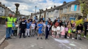 PlayStreet GroupPhoto: Adults and children in St Monica's Avenue gathered for a photo. Chalk drawings on the road.