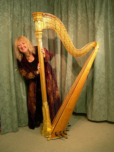 Annie Mawson MBE standing behind her harp