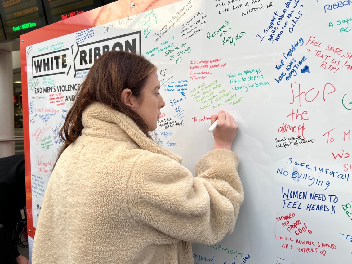 Councillor Nicky Brennan signing the White Ribbon pledge wall