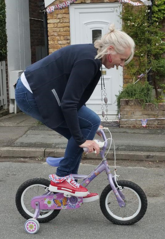 CC Lucy D'Orsi riding a bike-3: Chief Constable Lucy D'Orsi attempting to ride a small bicycle.