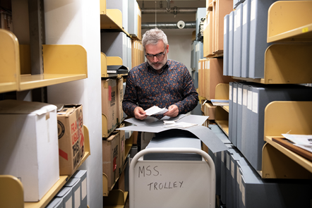 Curator Colin McIlroy in the stacks of the National Library of Scotland looking at archival material