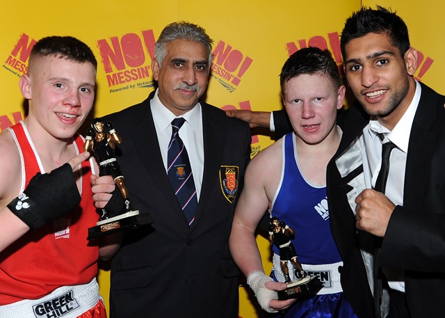 Morgan Jackson (red) from Gloves and John James (blue) from St Josephs in Newport collect their trophies from champion boxer Amir Khan at the No Messin' tri-national boxing competition. Joined by Yaqoob Hussein, from the British Amatuer Boxing Association