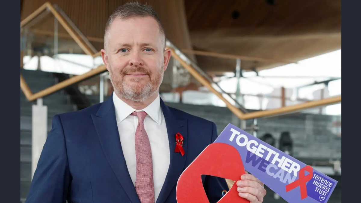 Cabinet Secretary for Health and Social Care outside the Senedd with banner-2