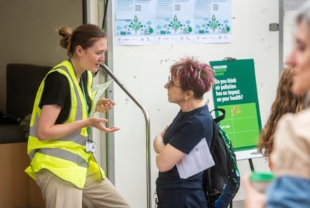 A staff member talking to a resident about air quality at an event