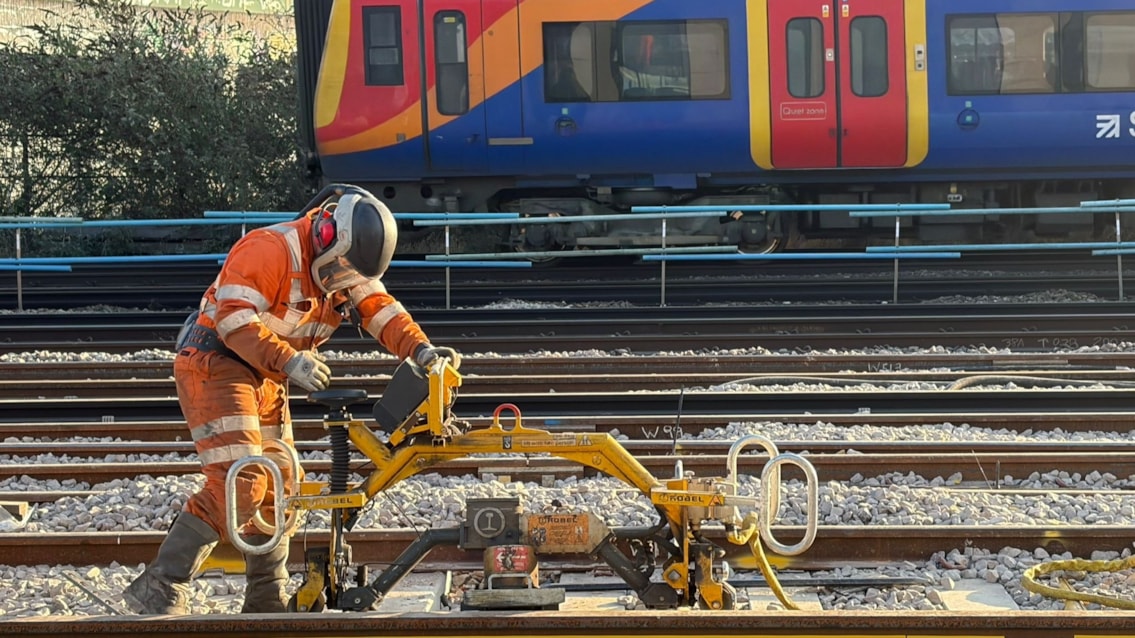 COMPLETED: Full service resumes between London Waterloo and Clapham Junction after upgrades to South Western Railway network: Work at Queenstown Road with a SWR train passing