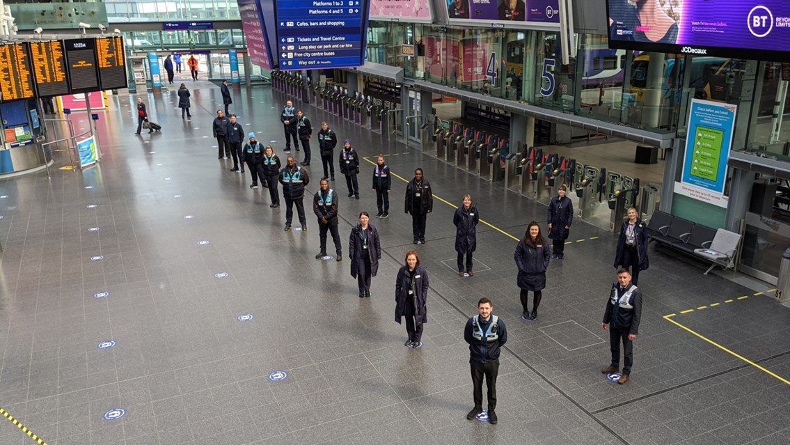 Train operator and station staff on new social distancing markers at Piccadilly station