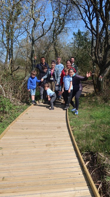 Group of Springboard parents and children on wooden walkway built at Johnston Community School