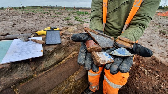 A Wessex Archaeologist shows post medieval pottery from the Coleshill Medieval Manor site: Copyright HS2 Ltd