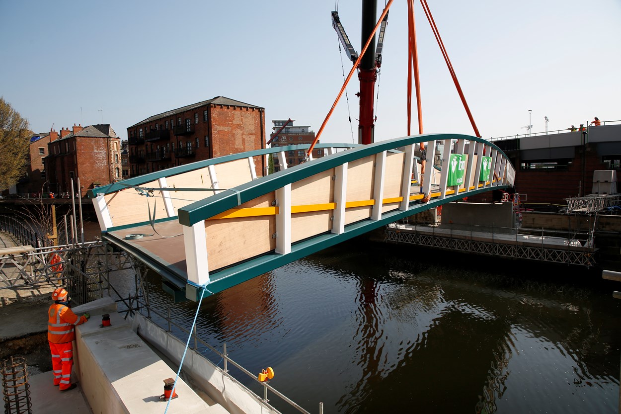 David Oluwale bridge installation: The David Oluwale bridge is lifted into place over the River Aire in Leeds. Engineers working on the David Oluwale bridge completed one of the project’s major milestones over the weekend, with cranes carefully placing the 40 tonne structure over the river where it will connect Sovereign Street to Water Lane. Credit BAM Nuttall.