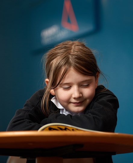 Ellie from Westfield Primary School in Runcorn reading a book donated by Avanti West Coast
