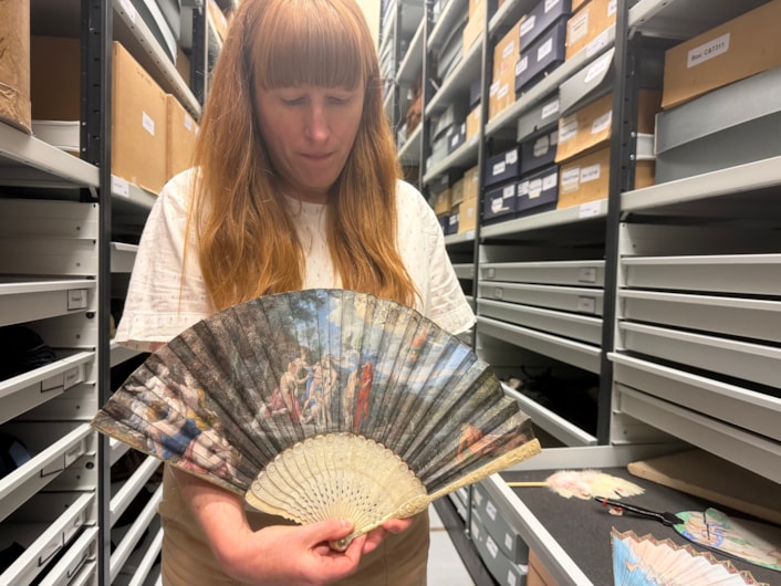 Antique fans: Curator Natalie Raw holds a stunning 350-year-old fan depicting a legendary scene from the Trojan War which is being conserved at Leeds Discovery Centre.
Crafted in around the 1680s, the beautiful folding hand fan, complete with sticks carved from antique ivory, captures The Judgement of Paris, a fateful mythical moment which saw the Trojan prince choose which of three ancient goddesses- Hera, Athena, or Aphrodite- was the most beautiful.