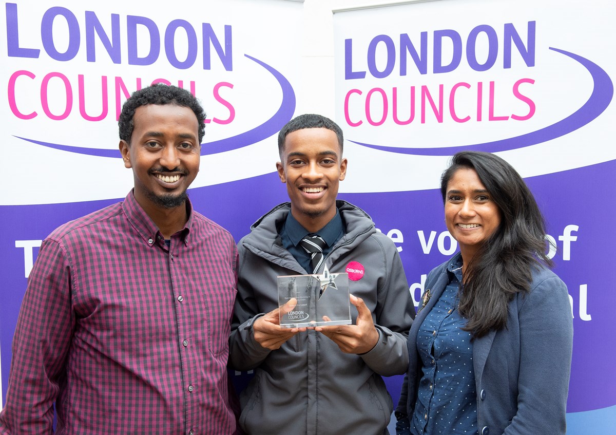 Usama Mohamed, centre, celebrates with Zak Hassan, a mentor at Jubba Youth Community Association, left, and Darshna Dhokia, Islington Council's youth employment and apprenticeships manager