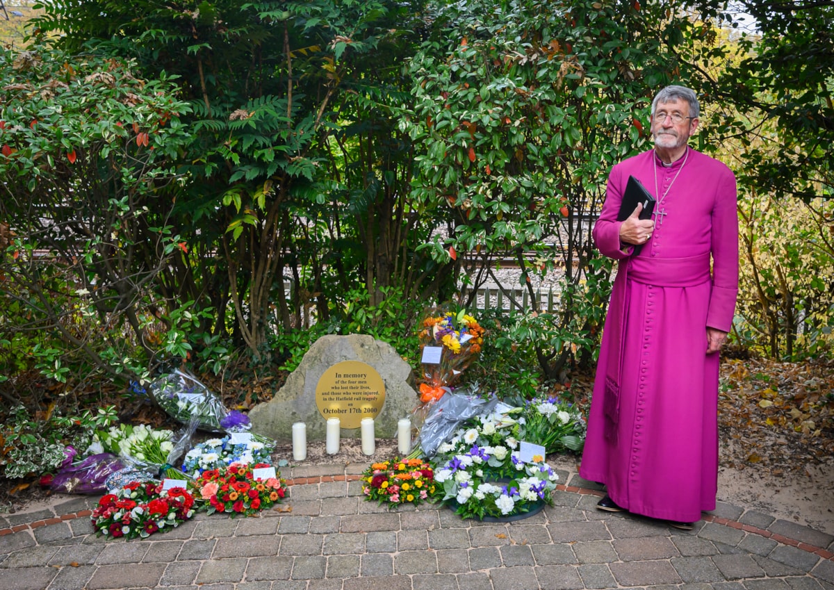 Bishop Rob Gillion alongside tributes at the Hatfield Rail Crash Memorial Garden, LNER