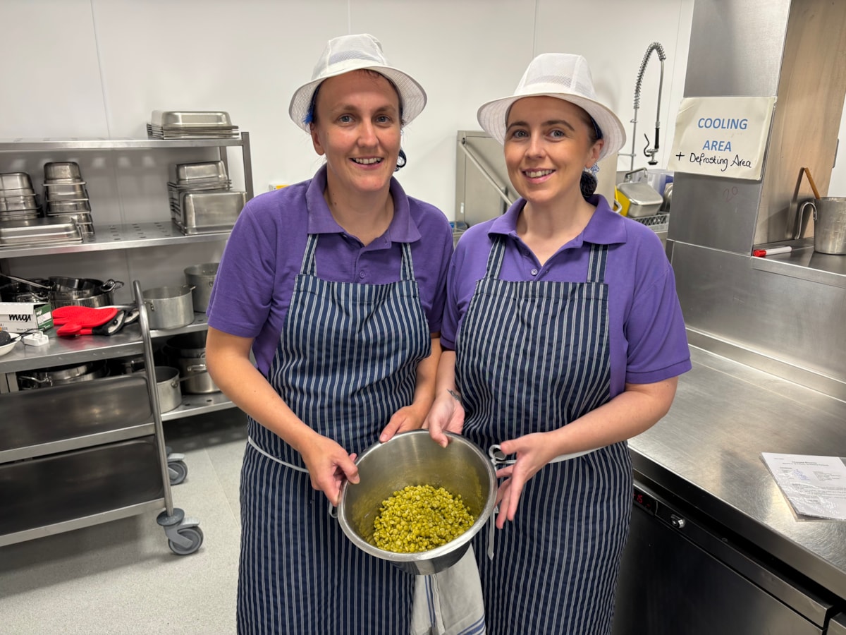 Catering staff holding a bowl of green peas