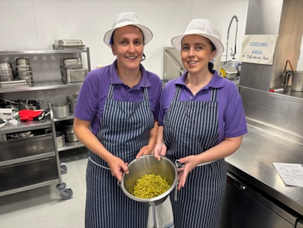 Catering staff holding a bowl of green peas