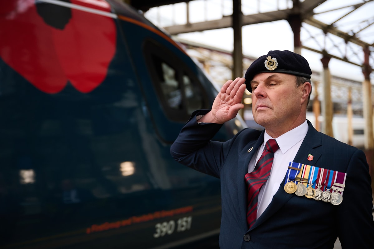 Avanti West Coast's Trainer and Assessor Andrew Walker salutes the Poppy Train at Crewe Station.