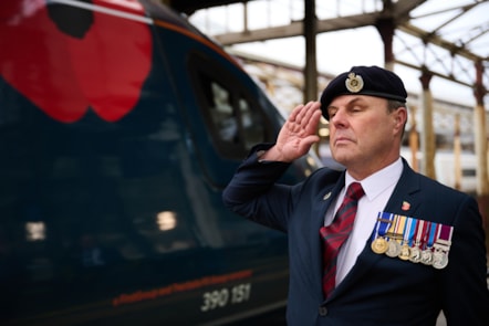Avanti West Coast's Trainer and Assessor Andrew Walker salutes the Poppy Train at Crewe Station.