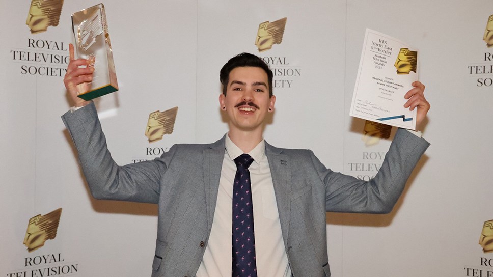 University of Cumbria student Peter Howarth holding aloft his his Royal Television Society North East and the Borders award and certificate
