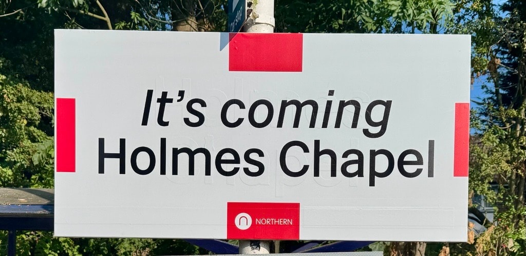 Holmes Chapel station sign with flag in background