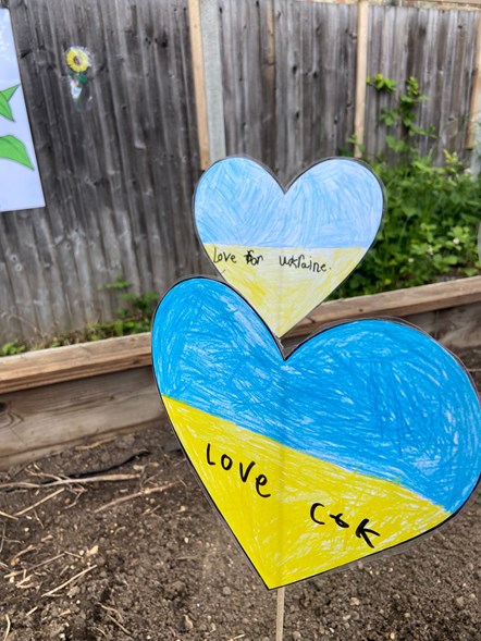 A raised bed displays hearts in the colours of the Ukraine flag with messages of solidarity, at Christ The King Catholic Primary School-3