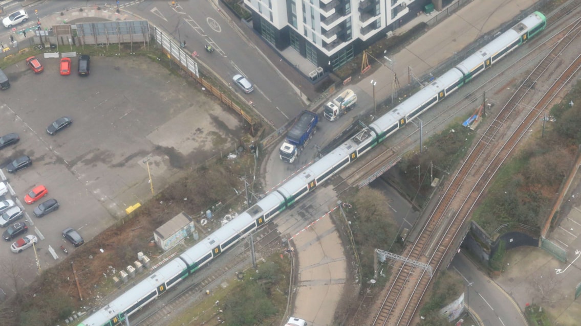 Aerial view of Mitre Bridge level crossing with train