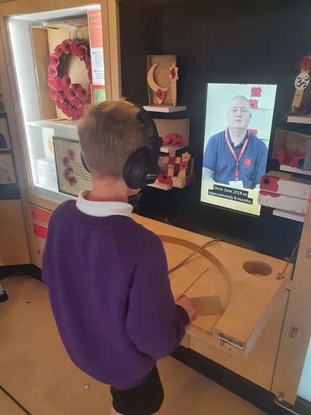 A pupil listens to a Veteran's story aboard Bud the Poppy bus, Popyyscotland's interactive mobile museum, which visited Seafield Primary School in Elgin.