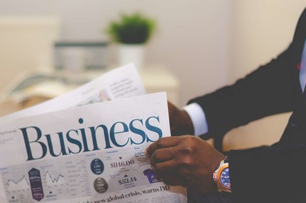 person holding business newspaper