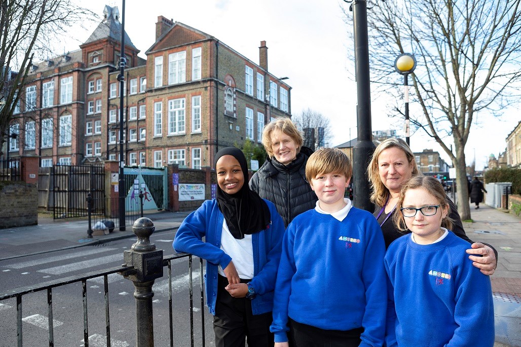 Cllr Champion (back row; on the left) and Ambler Primary School headteacher Juliet Benis (back row, on the right) pose with children at Ambler Primary School