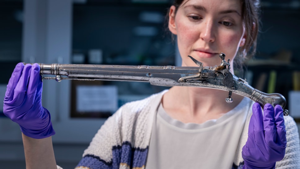Curator Ella Paul examines the pistol at National Museums Scotland. Image © Duncan McGlynn (2)